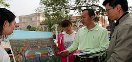 高清图：何成创作的油画“民园广场展新姿”绘制完成