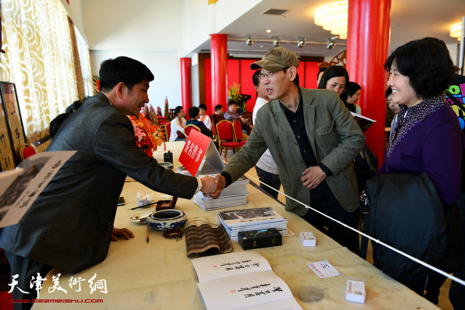 孟宪奎《蒙·大山情》画展“五·一”亮相天津水上公园，图为孟宪奎与画家王印强在画展现场。