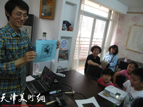 秦永超老师在给孩子们介绍版画的颜料、工具、制作过程演示