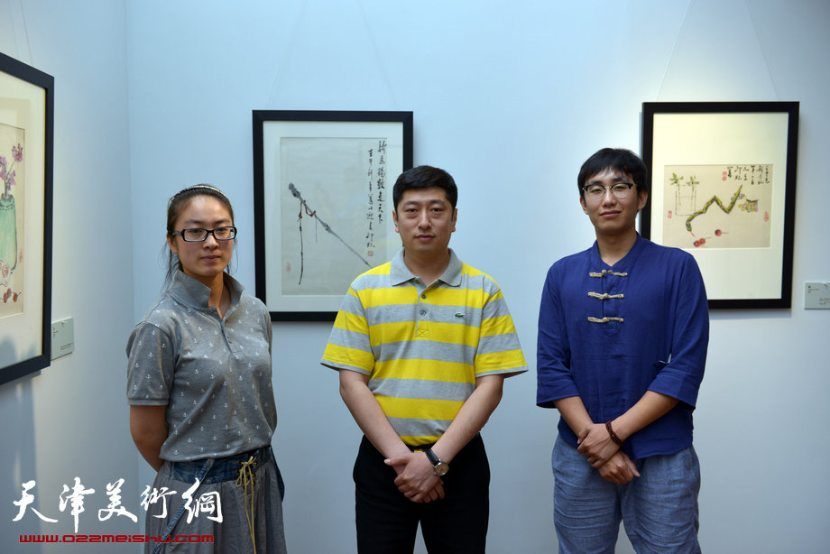 萧朗小写意花鸟画展5月26日在梅江国际艺术馆开幕，图为荣宝斋天津有限公司经理徐征与员工在画展现场观摩。