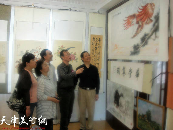 天津市第二届华侨华人书画展开幕，图为要华民为观赏者讲解大红鹰绘画
