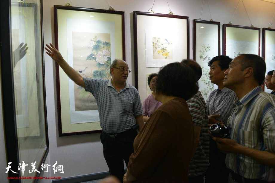 天津花鸟四家师生作品展在图书大厦书天艺苑开幕。图为史如源在画展现场为观众解画。