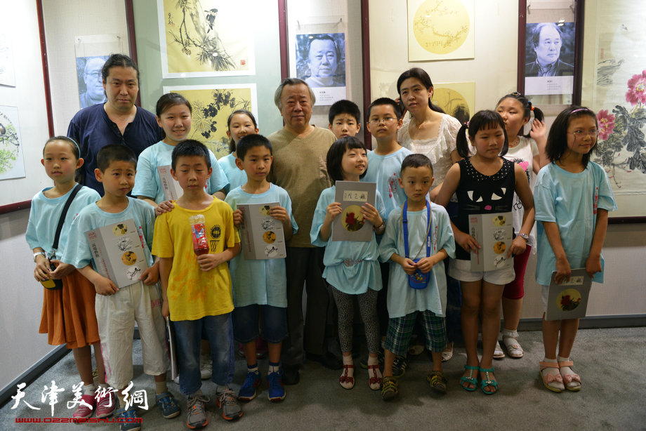 天津花鸟四家师生作品展在图书大厦书天艺苑开幕。图为阮克敏在画展现场与小观众在一起。