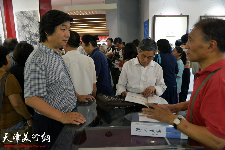 天津花鸟四家师生作品展在图书大厦书天艺苑开幕。图为翟洪涛在画展现场与观众交流。