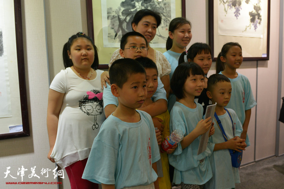 天津花鸟四家师生作品展在图书大厦书天艺苑开幕。图为画家马胜巧在画展现场与孩子们在一起。