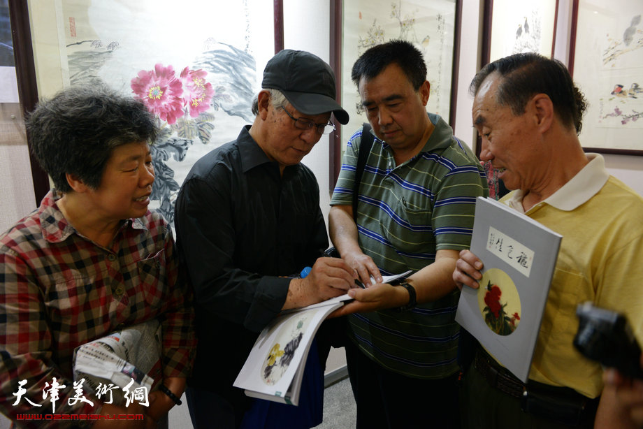 天津花鸟四家师生作品展在图书大厦书天艺苑开幕。图为贾宝珉在画展现场为读者签名留念。