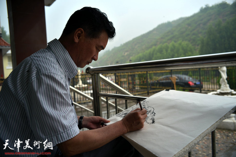 天津著名山水画家到阜平三道岭采风写生。陈之海在画雨中太行。