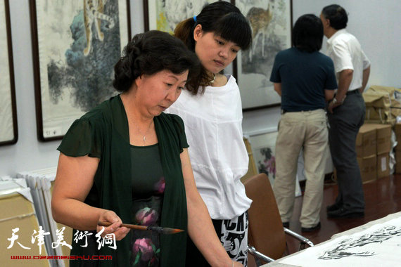 刘继卣弟子孙富泉画展在紫竹林画苑举办。图为冯字锦、马韵桐在画展现场助兴。