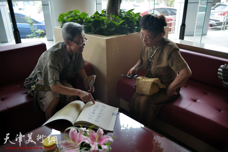 韩嘉祥书法精品亮相，展示吴派书法大家风范。图为观众在阅读“水墨•月动”韩嘉祥作品集。