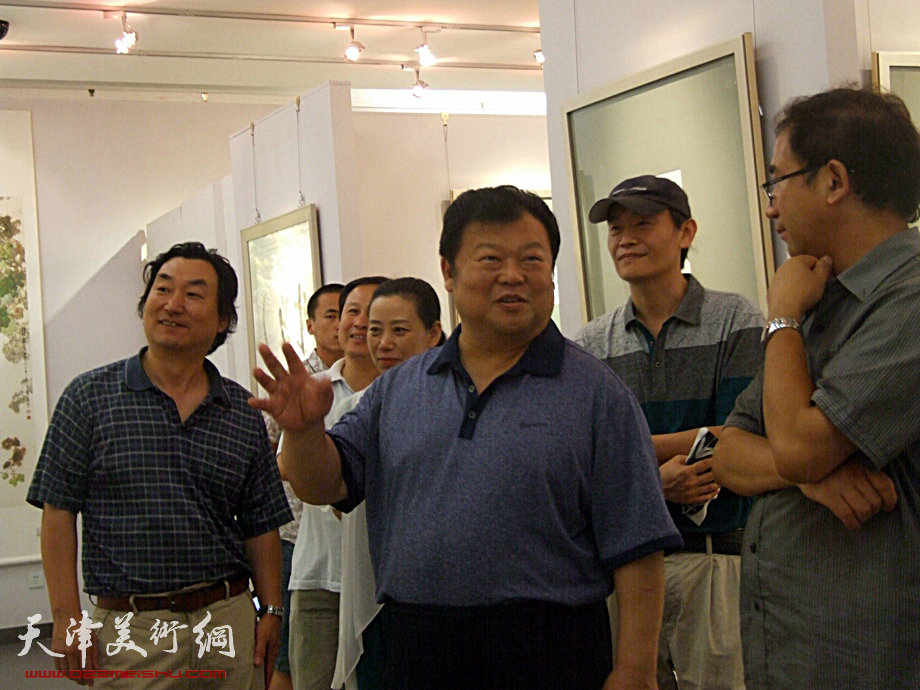 天津市委常委散襄军7月4日参观《和·心象》书画联展，天美时代艺术空间展厅内散书记与顿子斌交流对作品的看法。
