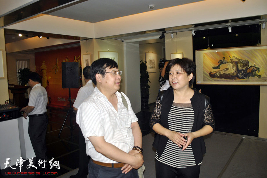 “古朴艺源—朴墨心画艺术巡回展”7月13日在北京中外首工美术馆举行。图为天津朴墨心画院院长朱红与嘉宾在画展上交谈。