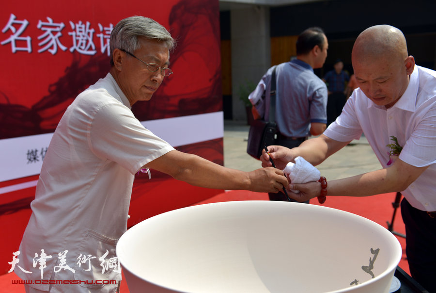 天津致园美术馆开馆仪式暨“殊涂同致—中国画名家风范展”8月24日在致园美术馆开幕，图为王心元在聚宝盆上签名。