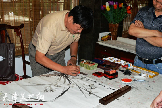 天津画家郭鸿春花鸟作品展在珠海大香山美术馆举行，图为郭鸿春在现场作画。