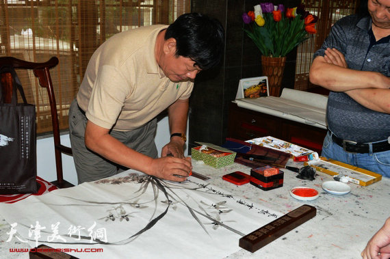 天津画家郭鸿春花鸟作品展在珠海大香山美术馆举行,图为郭鸿春在现场作画。