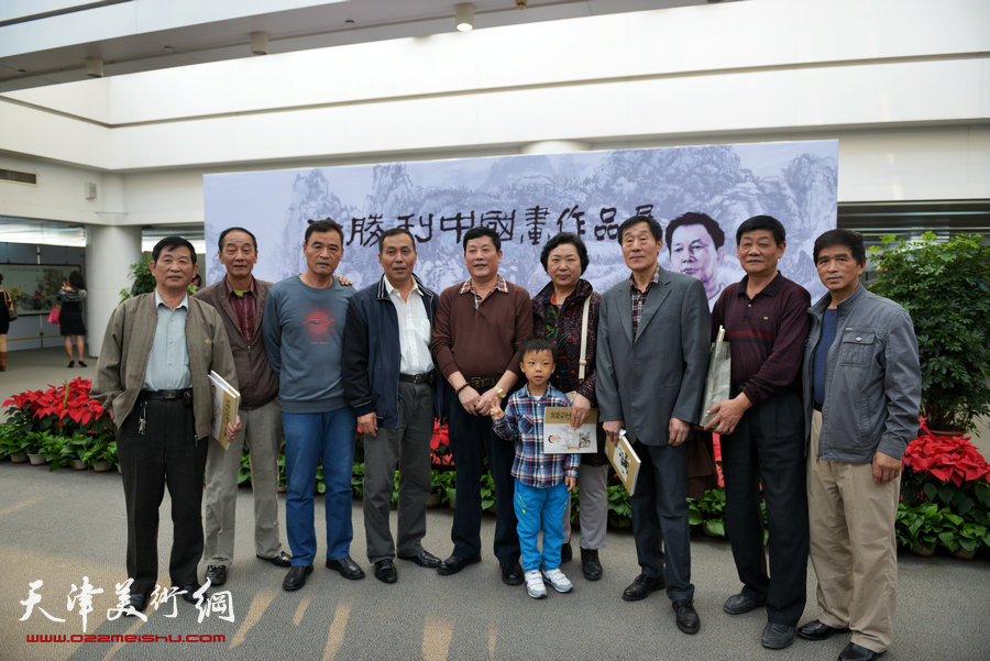 徐胜利中国画作品展10月18日在泰达图书馆展出，图为徐胜利与嘉宾在画展展牌前留影。