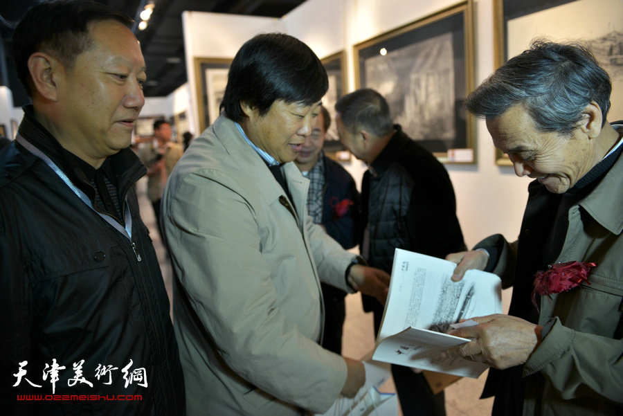 “全国第六届钢笔画展”11月1日在天津财经大学艺术馆开幕，图为天津美协主席曹德兆在画展现场与彭军、徐铸交流。