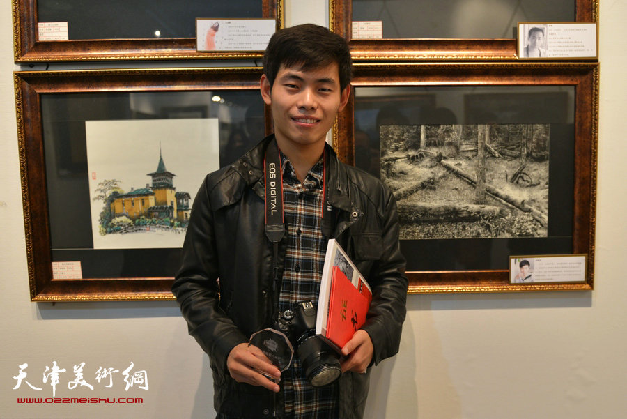 “全国第六届钢笔画展”11月1日在天津财经大学艺术馆开幕，图为山西画家冀晓伟在他的展出作品前。