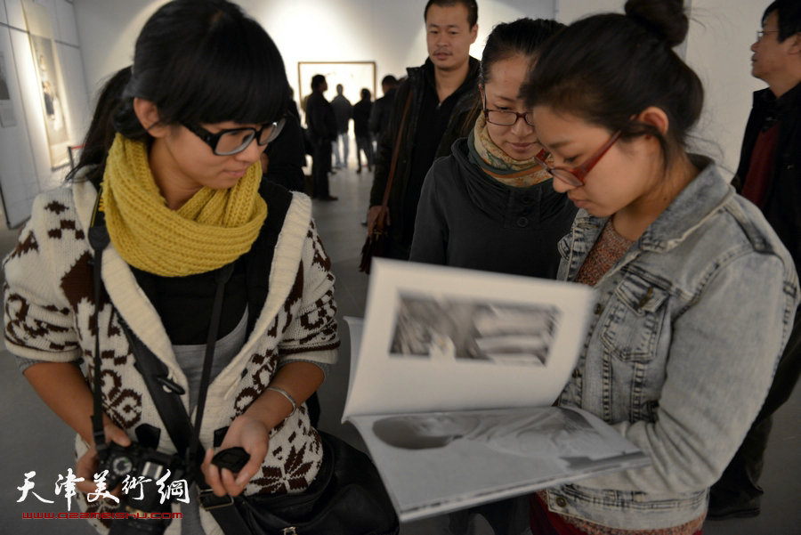 《行者无疆——中国当代水墨名家邀请展》11月5日在天津美术馆开幕。图为展览现场观众在阅览 《行者无疆——中国当代水墨名家作品集》。