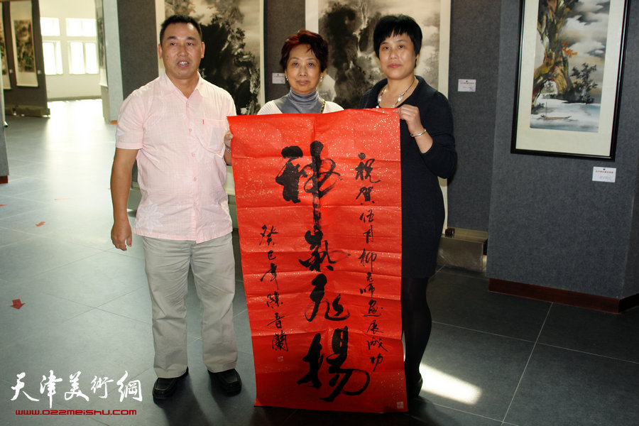 著名岭南派女画家陈音兰赴开平出席老师伍月柳画展，图为陈音兰为老师伍月柳画展送书法“神采飞扬”，左为开平美术馆馆长谢东达。