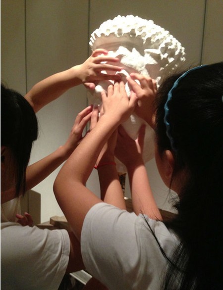 盲童在李秀勤的“触摸艺术”展览上触摸雕塑家为盲人做的塑像