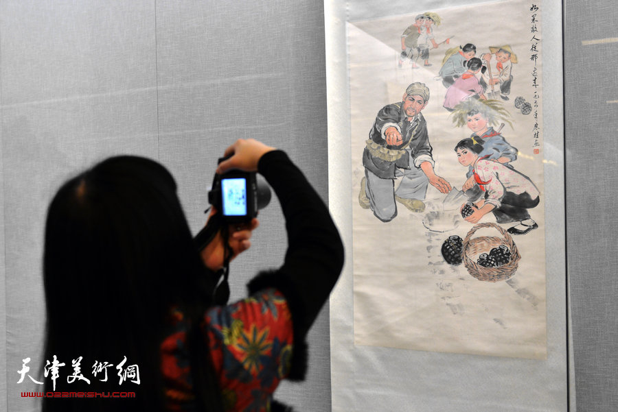 天津美术馆举办“红色经典—馆藏20世纪中国画展”，图为一观众拍摄单应桂中国画《如果敌人从那边过来》。