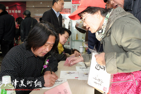 孙富泉、冼艳萍签售十二生肖连体明信片册，图为现场。