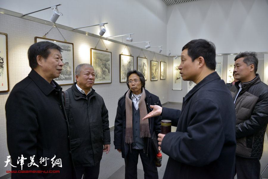 “跃马迎春京津画家国画新作展”1月15日在天津图书馆开幕，图为著名画家田均清、李宪章、书画家杂志社主编孙海与北京来的嘉宾交谈。