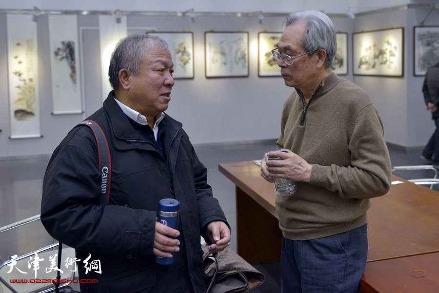 “跃马迎春京津画家国画新作展”1月15日在天津图书馆开幕，图为著名画家黄枕石与书画家杂志社主编孙海交谈。