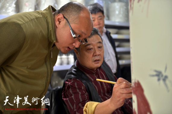 孙岩与著名画家王其华在研讨青花艺术。