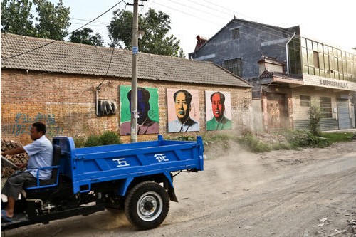 三张两米高的波普毛泽东画像悬挂在仇庄的主路旁