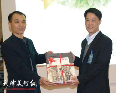 何建平（右）接受吴耀军捐赠的图书