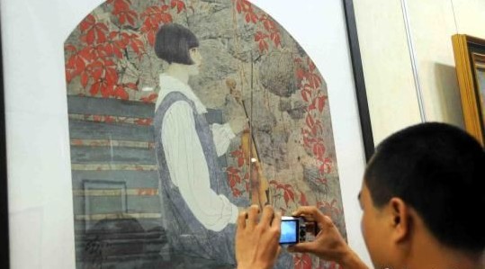 市民前来参观欣赏何家英先生的作品。