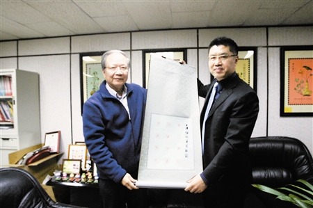图为天津参展团团长程亚杰把《马年邮戳图案》卷轴送给台湾邮政博物馆馆长江庆星（左）。 