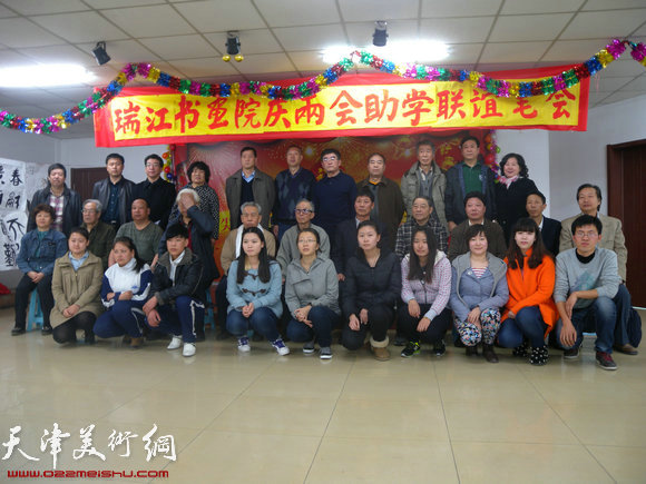 瑞江书画院举办献爱心助学助困活动，图为书画家们与受助学生合影