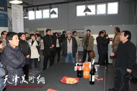 刘硕海(右一)向参观者介绍自己的版画作品。