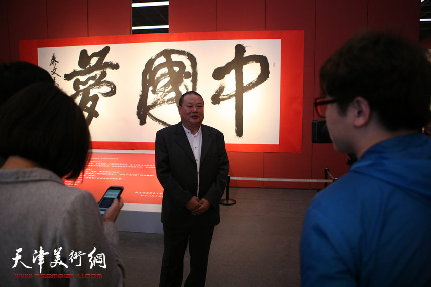 天容海色—马孟杰诗文书法展在山东美术馆开幕，图为马孟杰在书展现场接受媒体采访。