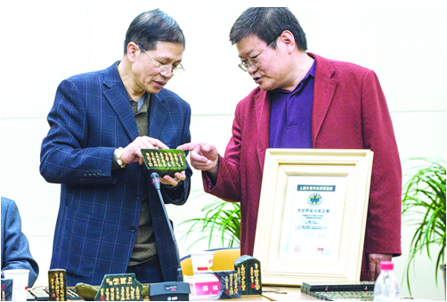 薛林（右）向参会人员展示了篆刻作品。