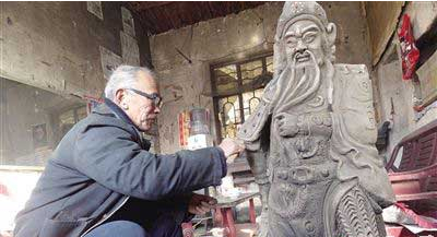 老人欲建古代忠义人物雕塑展室 图为老人正在制作关公雕塑