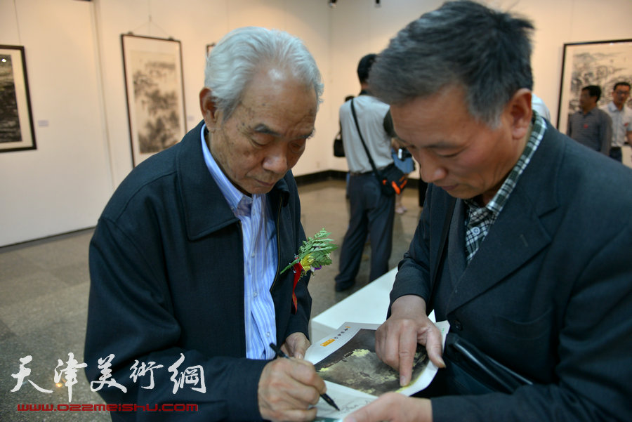 纪振民、姬俊尧山水画展在朱屺瞻艺术馆隆重开幕，图为纪振民为观众签名。