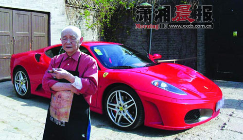 北京万荷堂家中，一身工装的黄永玉。身后的红色法拉利F430是他的最爱。图片由黄永玉本人提供