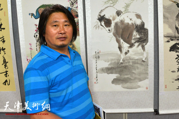 图为孙富泉与他的展出作品：《一定赢》。