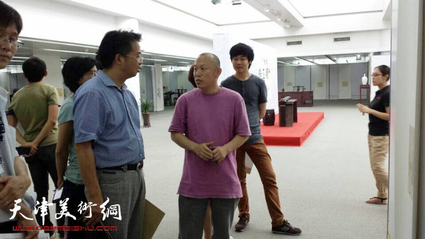 隋牟作品展6月24日在滨海新区开幕,图为隋牟与来宾在展览现场。