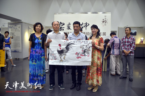 图为王旭向展览赠送画作：“大吉大利”