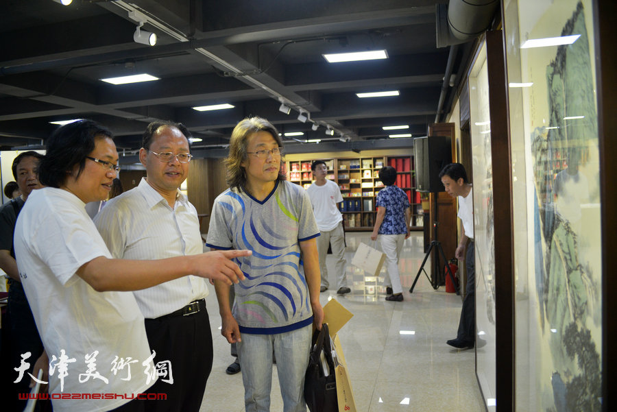 “画韵书香”天津人民美术出版社建社60周年职工书画作品展8月14日在天津人美艺术展厅开幕。图为赵均、杨惠东、刘云峰观赏作品。