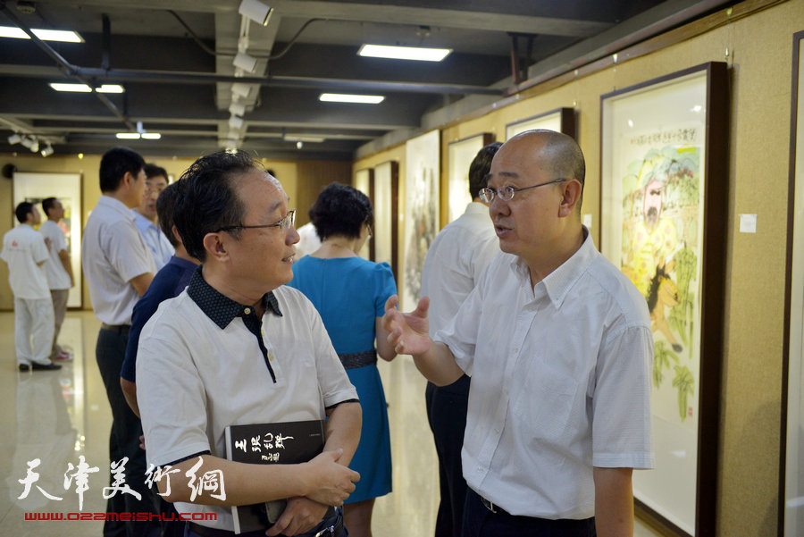 “画韵书香”天津人民美术出版社建社60周年职工书画作品展8月14日在天津人美艺术展厅开幕。图为左起：何东、马驰在展览现场。