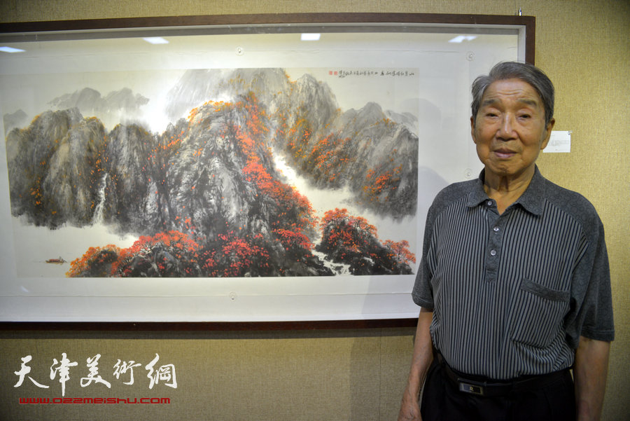 “画韵书香”天津人民美术出版社建社60周年职工书画作品展8月14日在天津人美艺术展厅开幕。图为赵兵凯在其作品《山茶红时胜似春》前。