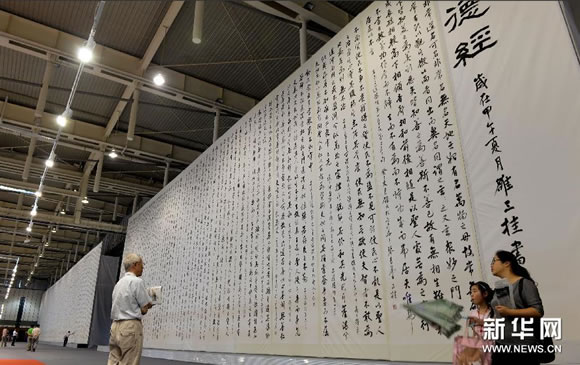 几名参观者在雒三桂巨幅书法作品前小憩