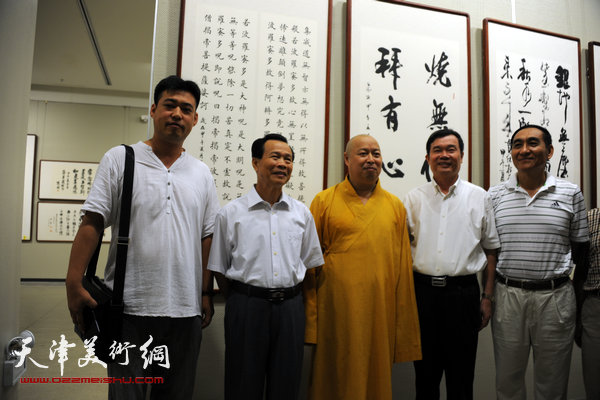 图为陈鹏（左一）与印顺大和尚，海南省政协副主席王应际，海南省政协副主席陈成在其展出的作品前。