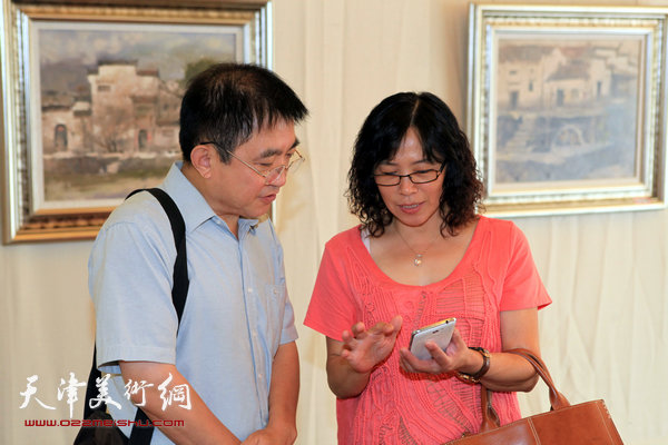 天津知名油画家新作品在中惠团泊湾展出，图为油画家王文元、杜兵在画展现场。
