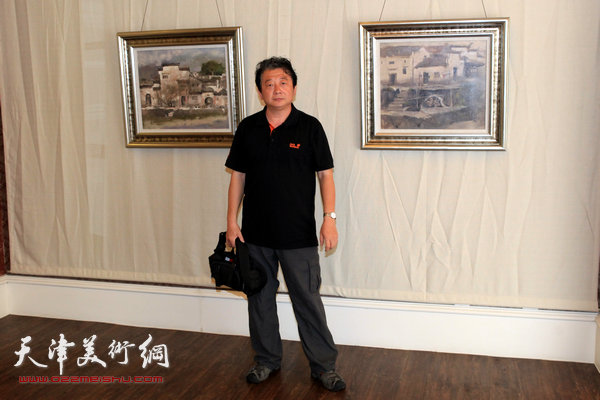 天津知名油画家新作品在中惠团泊湾展出，图为油画家沙志国在画展现场。